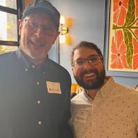 Two alumni laugh together